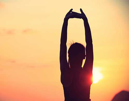 healthy fitness yoga woman stretching at sunrise seaside