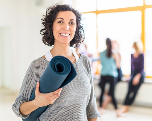 woman holding yoga mat