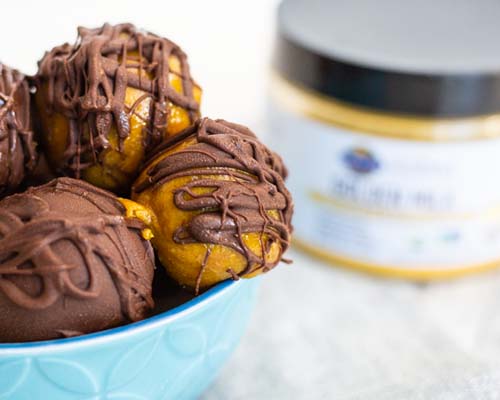 Golden Milk Truffles in a bowl with mykind golden product in the background Golden Milk Truffles in a bowl with mykind golden product in the background
