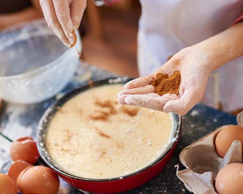Spice Up Your Health With a Shake or a Dash - Women adding spice to a mix Spice Up Your Health With a Shake or a Dash - Women adding spice to a mix