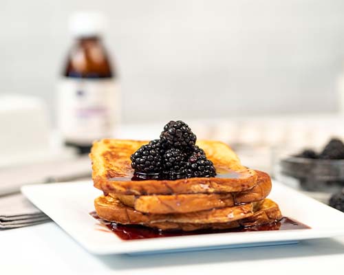 French Toast stacked with syrup and berries