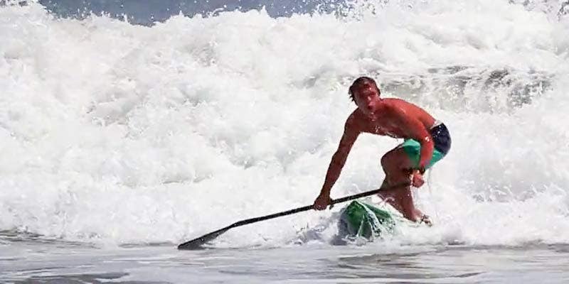 Paddleboard Racer Kieran Grant Riding a Wave Paddleboard Racer Kieran Grant Riding a Wave