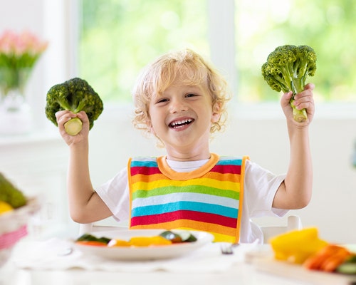 kid playing with vegetables