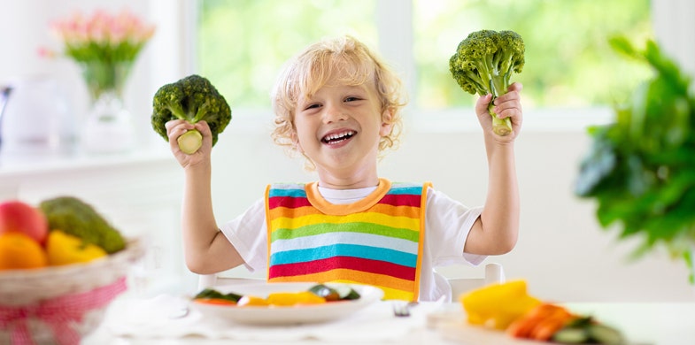 kid playing with vegetables