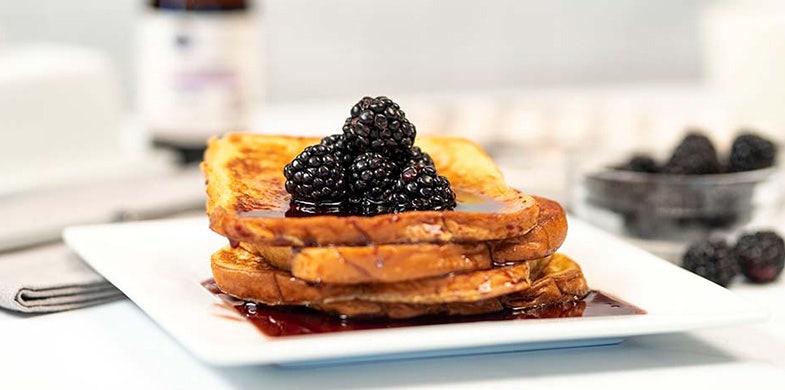 French Toast stacked with syrup and berries