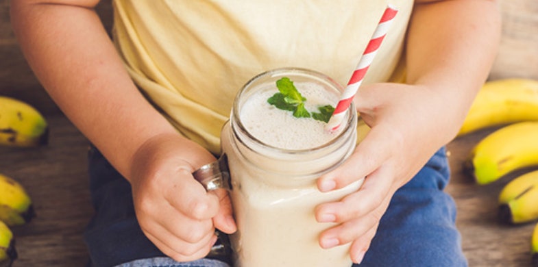 kid holding smoothie with straw