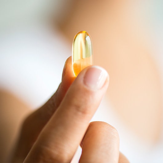 person holding omega-3 pill